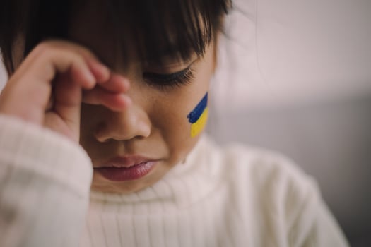 A child with the flag of Ukraine is crying. Sadness longing hope. Children's tears from the war. Evacuation of civilians. Freedom to Ukraine photo