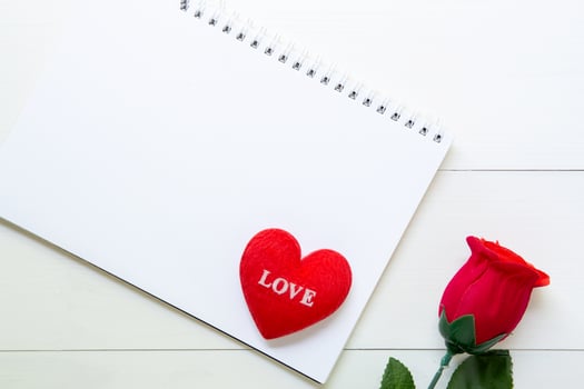 Present red rose flower and notebook and heart shape with copy space on wooden table, 14 February of love day with romantic, valentine holiday concept. photo