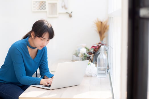 Beautiful portrait asia young woman working online on laptop sitting at cafe shop, professional female freelance using notebook computer, business and communication concept. photo