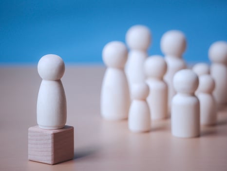 Wooden figure standing on the wooden block to talking leadingship for influence, empowerment and inspiration for crowd. Leader with influence, leader team and successful competition winner concept. photo