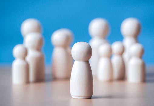 Wooden figure standing on the wooden block to talking leadingship for influence, empowerment and inspiration for crowd. Leader with influence, leader team and successful competition winner concept. photo