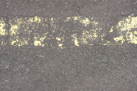 old road surface has yellow lines peeling off. photo