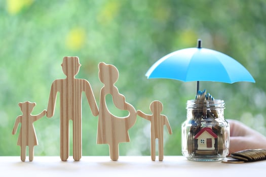 Protection,Model family with hand holding the umbrella and stack of coins money in the glass bottle on natural green background, Finance insurance and Safe investment concept photo