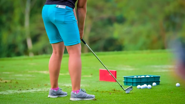 Golfer pushing white golf ball to hole at golf course in golf competition game , sunlight rays and blur background photo