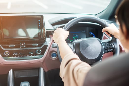woman driver driving a car on the road, hand controlling steering wheel in electric modern automobile. Journey, trip and safety Transportation concepts photo