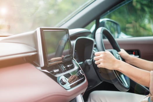 woman driver driving a car on the road, hand controlling steering wheel in electric modern automobile. Journey, trip and safety Transportation concepts photo