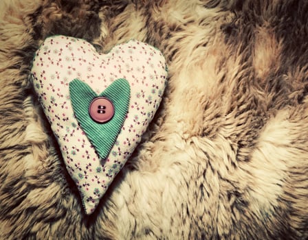 Vintage handmade plush heart pillow on the soft blanket photo