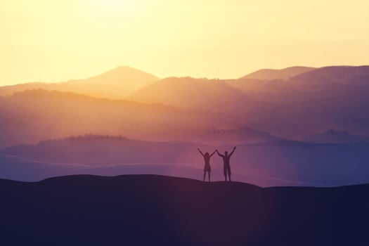 Happy man and woman standing on a hill photo