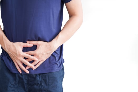 Man with abdominal pain, stomach ache on white background, painful area highlighted in red photo