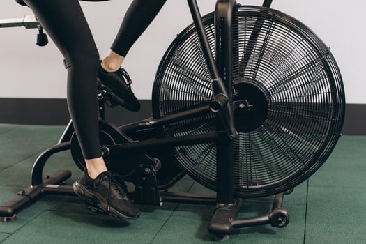 Crossfit woman doing intense cardio training on exercise air bike photo