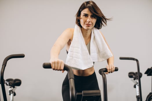 Crossfit woman doing intense cardio training on exercise air bike photo