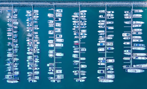 Marine port for yacht, motorboat, sailboat parking service and moorings for luxury and wealthy millionaire in aerial view with many ships anchoring along the dock bay photo