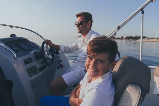 Father and son enjoy their vacation together while riding a luxury boat at sea. Selective focus photo