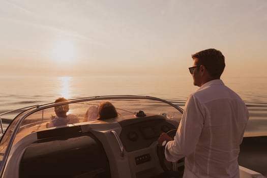 A senior couple in casual outfits with their son enjoy while riding a boat at sea at sunset. The concept of a happy family. Selective focus photo