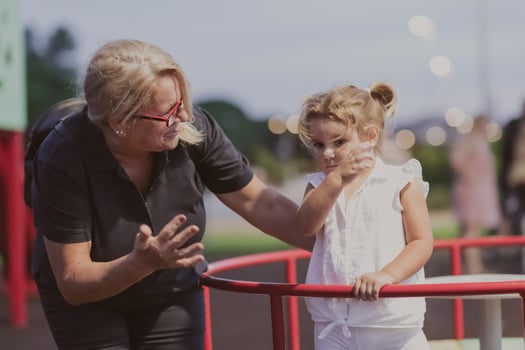 An older grandmother is playing with her grandson in the park at sunset. Selective focus photo