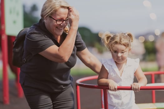 An older grandmother is playing with her grandson in the park at sunset. Selective focus photo