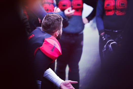 american football player discussing strategy with his team photo