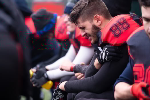 american football player holding the injured shoulder photo