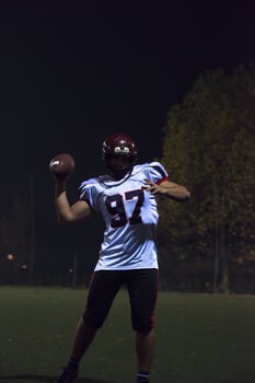 american football player throwing rugby ball photo
