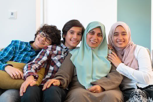 Middle eastern family portrait single mother with teenage kids at home in living room. Selective focus photo