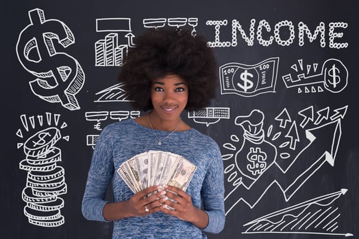 black woman holding money on gray background photo
