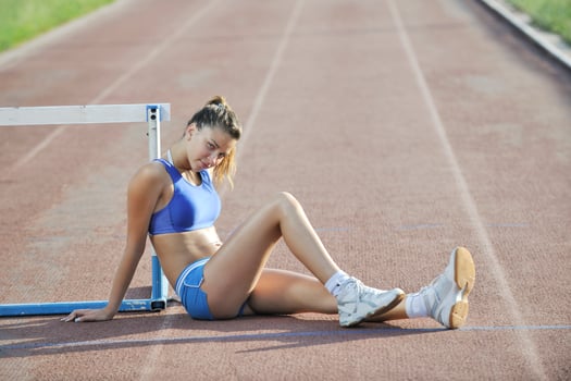 happy young woman on athletic race track photo
