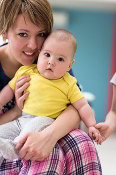 Portrait of young happy mother holding newborn baby boy photo