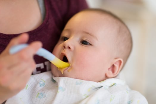 mother with spoon feeding little baby photo