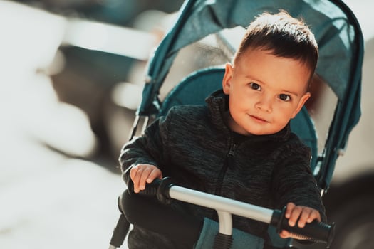 Sweet baby boy in a stroller bicycle outdoors. Little child in a pram. Infant kid in a pushchair. Spring walks with kids. photo