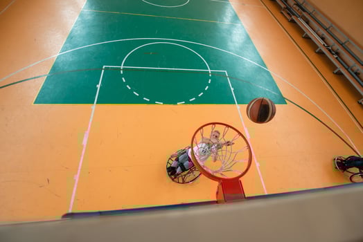 tow view photo of a war veteran playing basketball in a modern sports arena. The concept of sport for people with disabilities