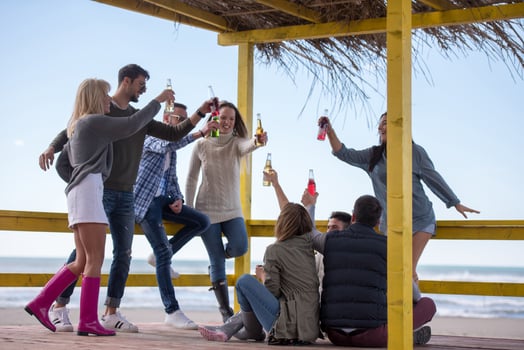 Group of friends having fun on autumn day at beach photo