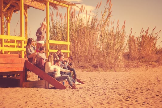 Group of friends having fun on autumn day at beach photo