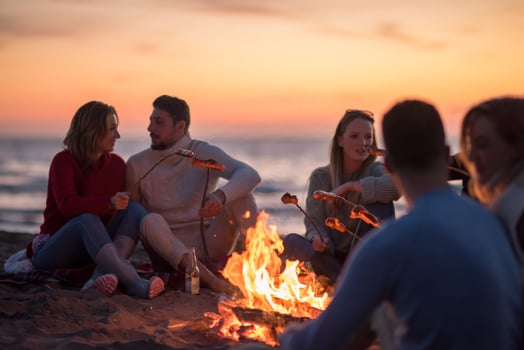 Group Of Young Friends Sitting By The Fire at beach photo