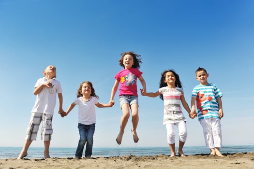 happy child group playing  on beach photo