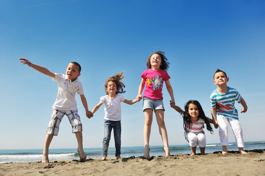 happy child group playing  on beach photo