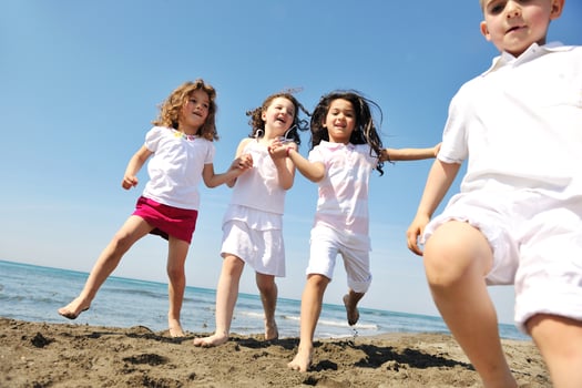 happy child group playing  on beach photo