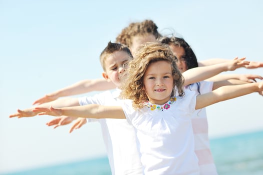 happy child group playing  on beach photo