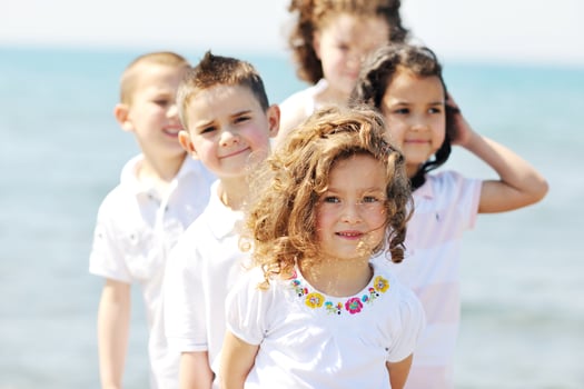 happy child group playing  on beach photo