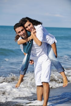 happy young couple have fun at beautiful beach photo