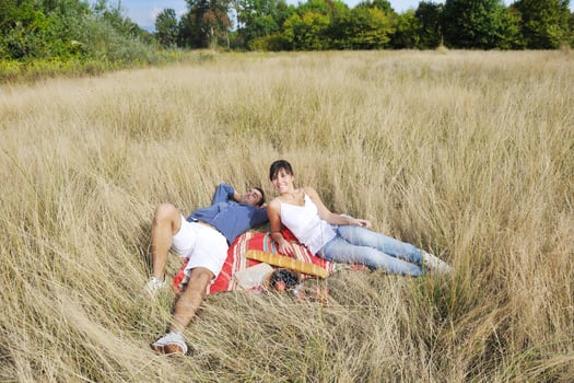 happy couple enjoying countryside picnic in long grass photo