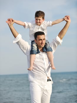 happy father and son have fun and enjoy time on beach photo