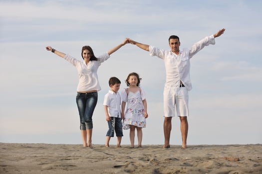 family on beach showing home sign photo