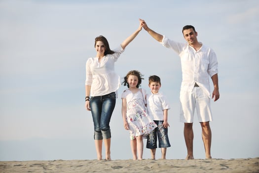 family on beach showing home sign photo