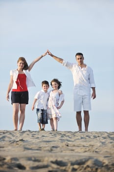 family on beach showing home sign photo