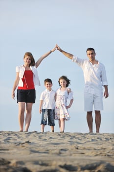 family on beach showing home sign photo