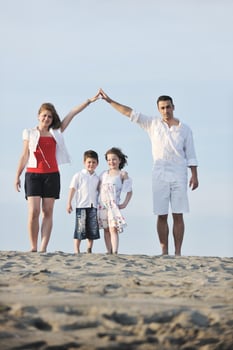 family on beach showing home sign photo