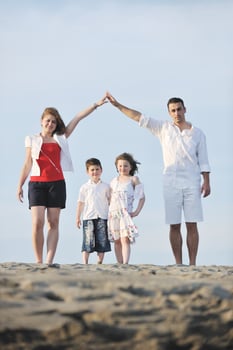 family on beach showing home sign photo
