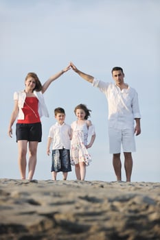 family on beach showing home sign photo