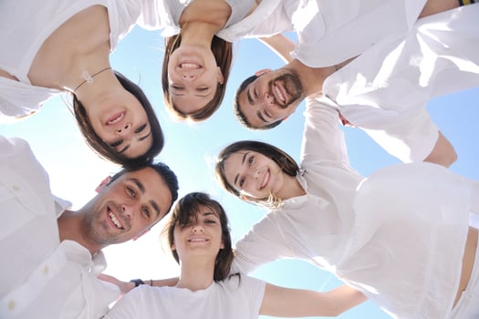 Group of happy young people in circle at beach photo