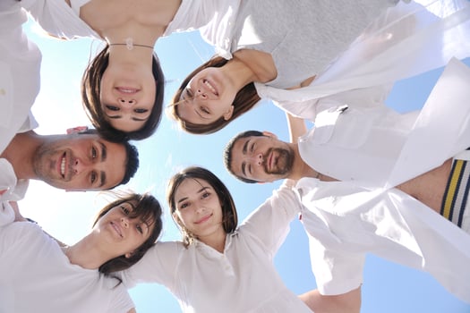 Group of happy young people in circle at beach photo